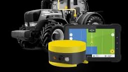 Rød traktor med slåmaskin står på en eng med nyslått gress en solrik dag.
