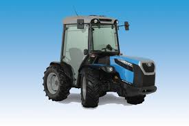 En grønn traktor med rundballepakker som pakker høyballer i plast ute på et jorde.
